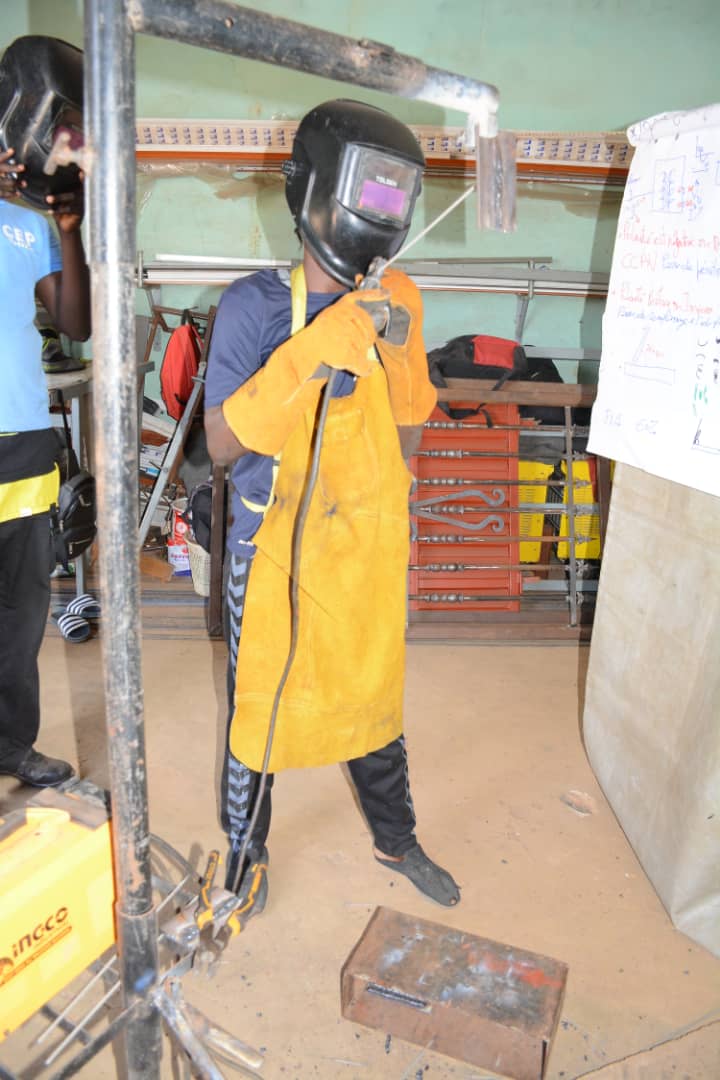 Stagiaire en soudage avec masque et tablier de cuir